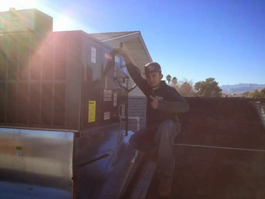HVAC technician performing HVAC Inspection on a rooftop unit in Northfield